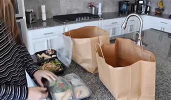 customer opening food delivery containers to serve meal