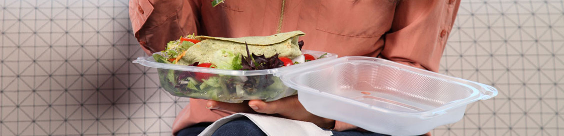 customer eating lunch out of clear hinged food container