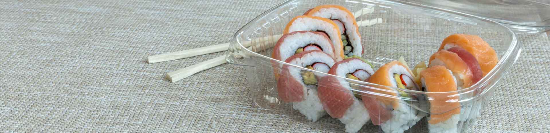 sushi in clear hinged container on table