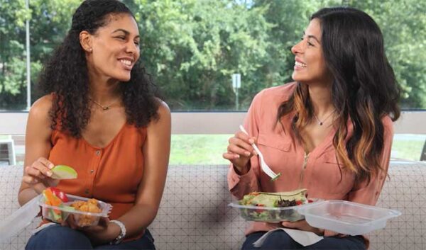 2 women eating from convenient store packaging