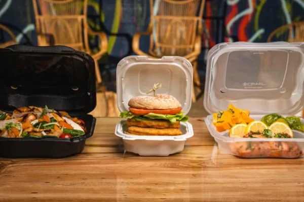Clover hinged containers on counter with food