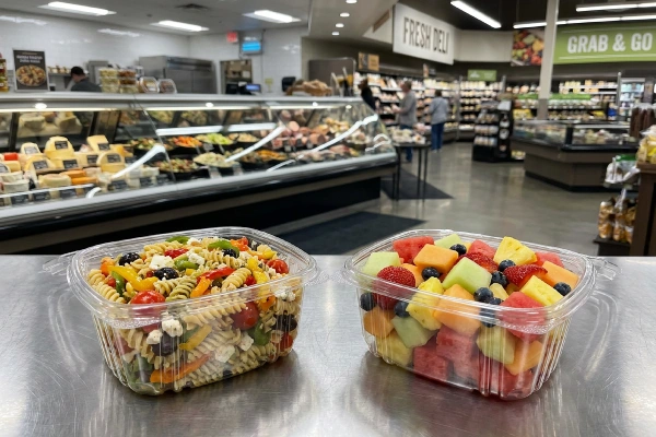 food containers filled with pasta salad, fruit salad